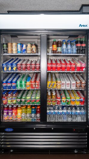 A vending machine stocked with various beverages including sodas, juices, and bottled drinks. - Economy Suites - Fairgrounds (Tulsa)