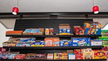 A shelf stocked with various snack items including Honey Buns, popcorn, and boxed snacks.