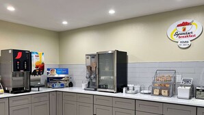 A breakfast area with a coffee machine, a refrigerator, and a sign indicating 'Superstart breakfast' hours.