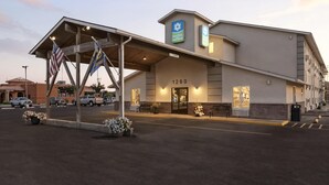 A hotel with a covered entrance, American and state flags, and a sign indicating the address 1260. - SureStay Hotel by Best Western Twin Falls (Twin Falls)