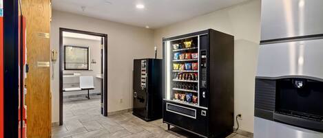 A room with a vending machine, a microwave, and a refrigerator.