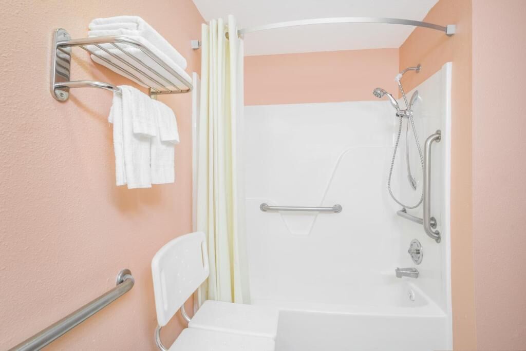 Ein Badezimmer mit Dusche, Toilette und Handtuchhalter.