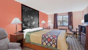 Habitación de hotel con una cama grande, dos mesitas de noche con lámparas, un escritorio con silla, televisor y una ventana con cortinas.