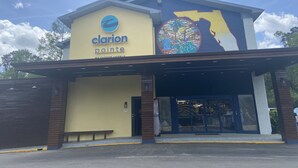 Un hotel llamado Clarion Pointe con un gran mural en la fachada.