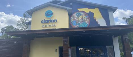 A hotel named Clarion Pointe with a large mural on the side.