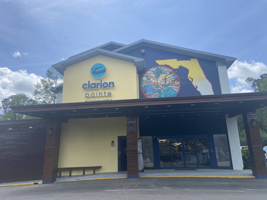 A hotel named Clarion Pointe with a large mural on the side.
