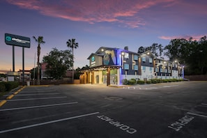 A hotel with a modern design, a parking lot, and a clear sky. - Clarion Pointe Tallahassee-State Capitol (Tallahassee)