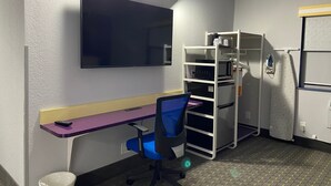 A compact room with a desk, chair, and a built-in microwave. - Clarion Pointe Tallahassee-State Capitol (Tallahassee)