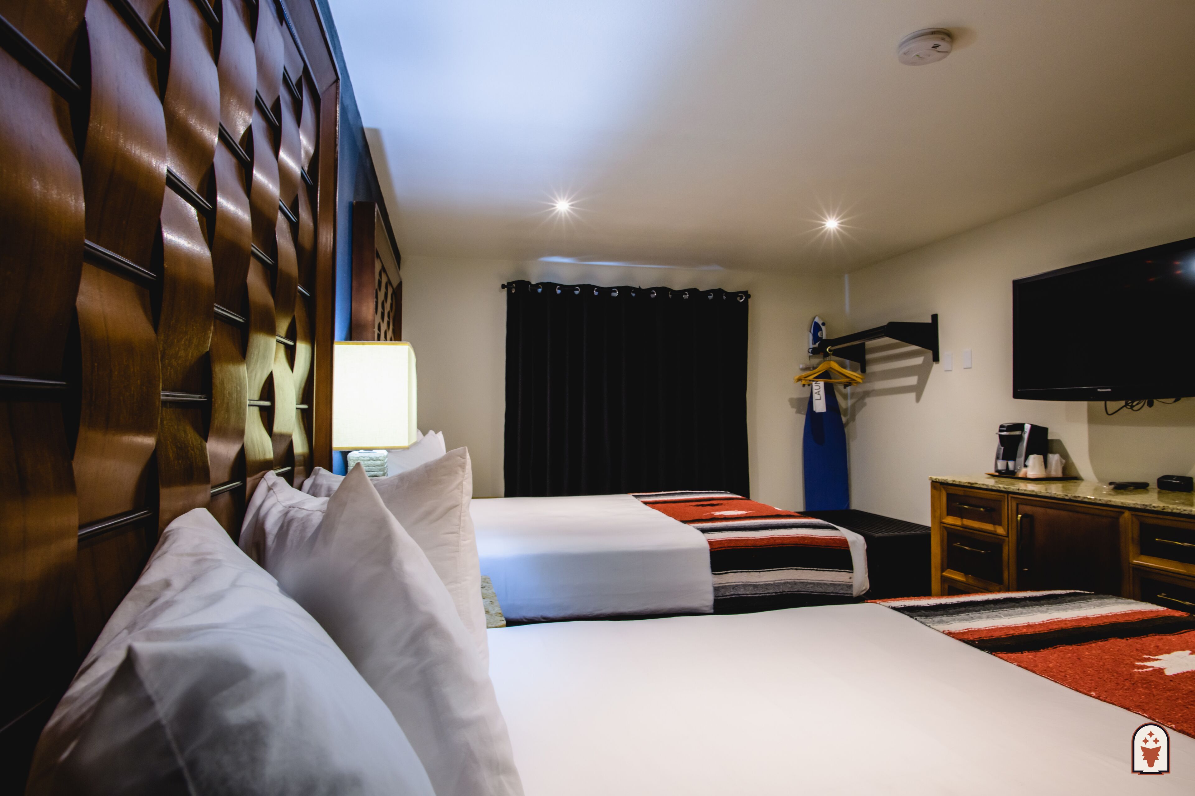 Hotelkamer met twee bedden, een flatscreen-tv, een bureau met koffiezetapparaat en een kledingkast.