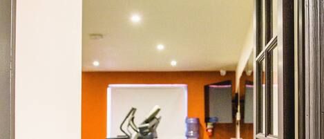 A gym with exercise equipment, a whiteboard, and a water dispenser.