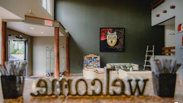 A reception area with a 'Welcome' sign, a painting of a wolf's face, and a display of magazines.