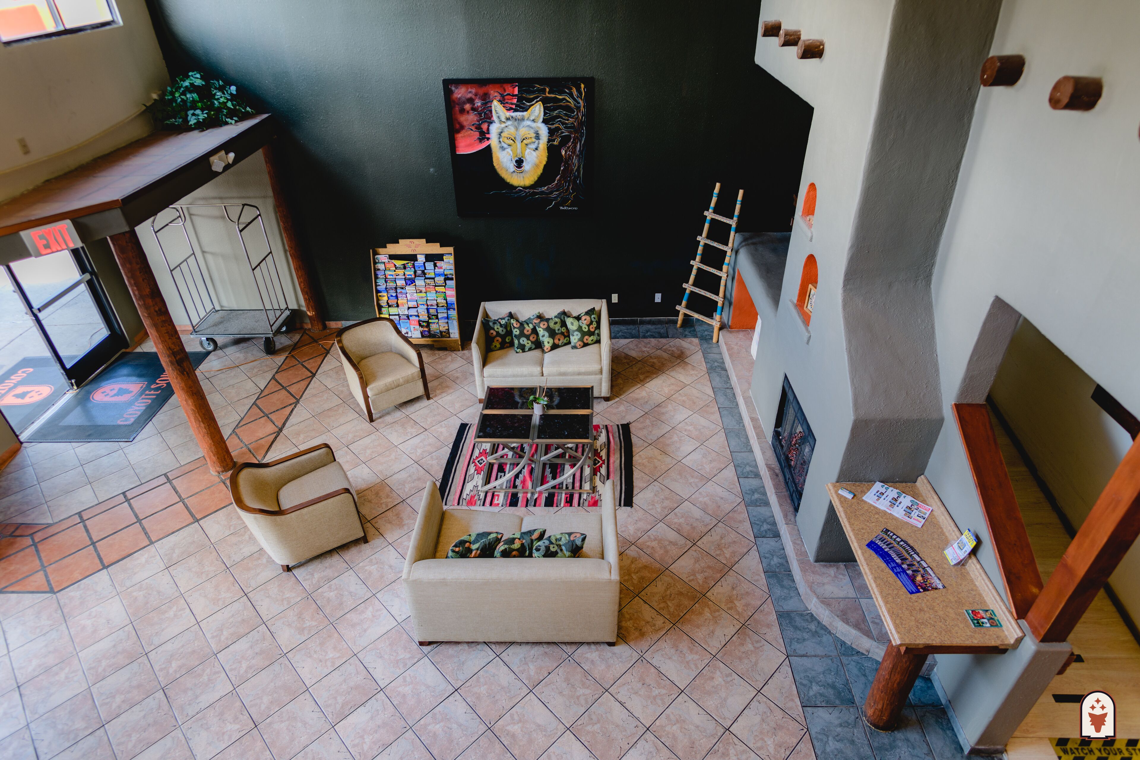 Un vestíbulo con un sofá, una mesita con revistas, un cuadro en la pared y una escalera.