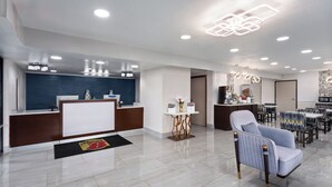 Un moderno vestíbulo de hotel con mostrador de recepción, zona de estar y comedor.