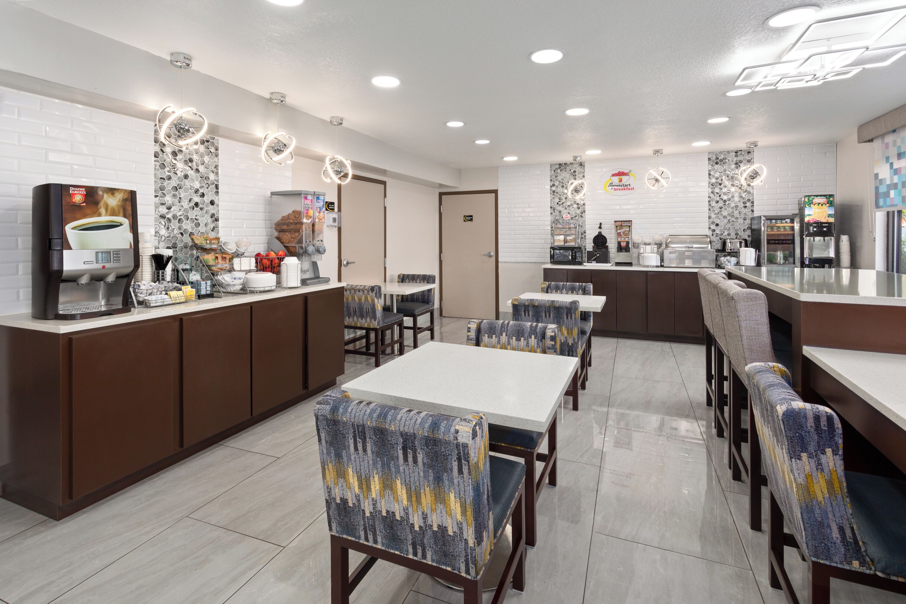 A modern cafe with bar seating, a coffee machine, and a counter with various food items.