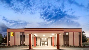 A modern hotel entrance with a clear sky.