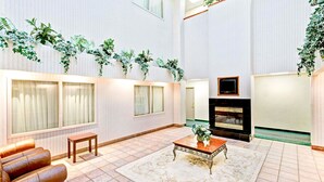 A spacious living room with a fireplace, a sofa, a coffee table, and a large window.