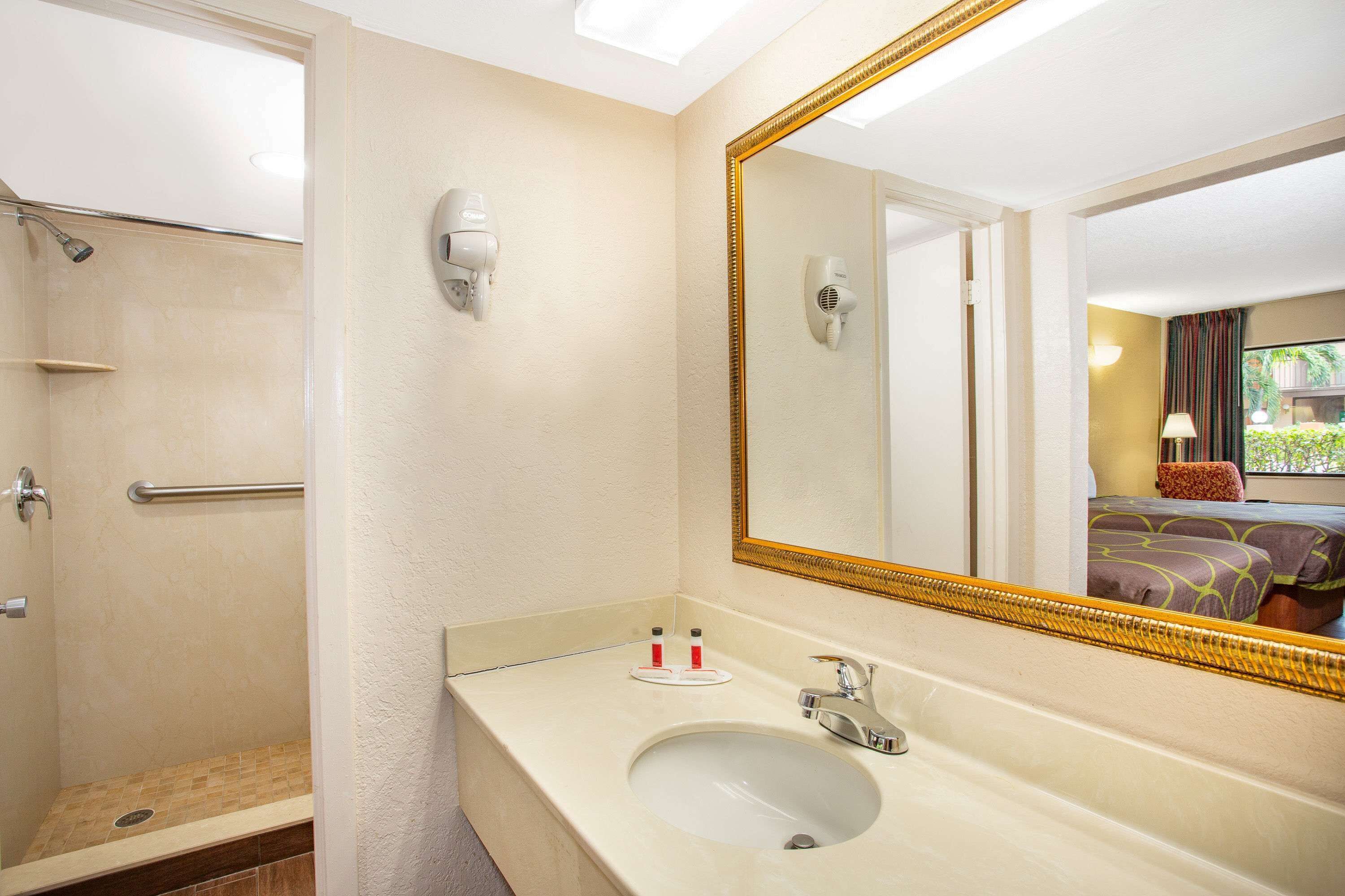 Un baño con lavamanos, espejo y ducha.