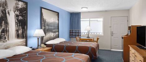 Une chambre d’hôtel avec deux lits, un bureau, une chaise, une télévision et une porte.