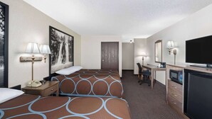 Une chambre d’hôtel avec deux lits, un bureau, une télévision et un four à micro-ondes.