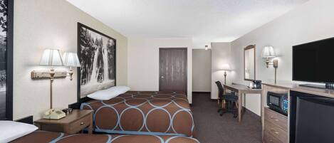 A hotel room with two beds, a desk, a television, and a microwave.