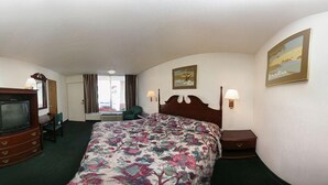 Une chambre d’hôtel équipée d’un lit, d’une télévision, d’un bureau et d’une chaise.