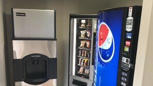 A vending machine with a Pepsi logo, a refrigerator, and a microwave.