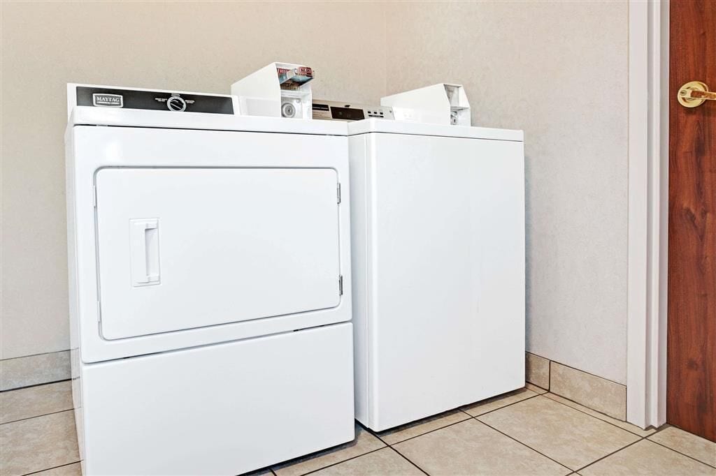 A white wall-mounted washer and dryer unit with a control panel and a door handle.