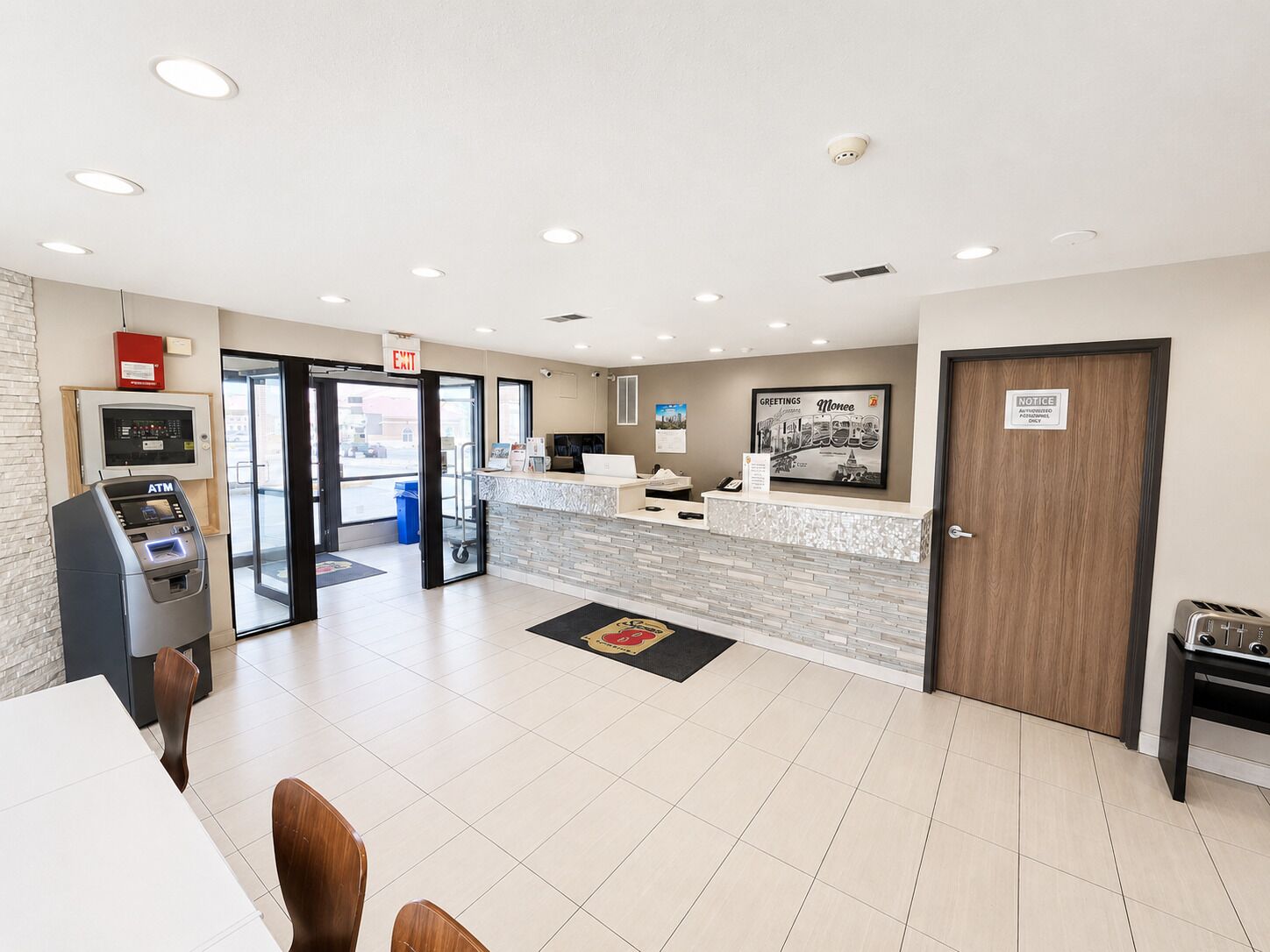 A hotel reception area with an ATM, a reception desk, a notice board, and a door marked 'NOTICE AUTHORIZED PERSON ONLY'.