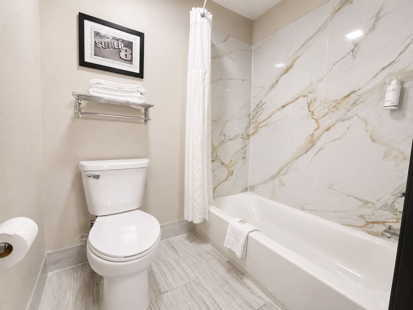 A bathroom with a toilet, a bathtub, a shower curtain, and a towel rack.