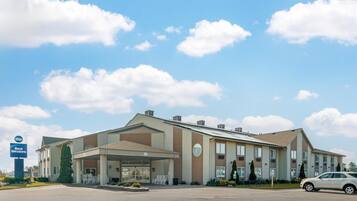 A hotel with a covered entrance, a parking lot, and a Best Western sign.