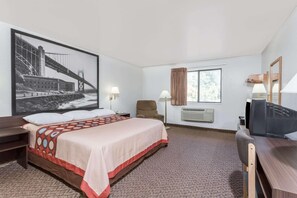 Una habitación de hotel con una cama grande, un escritorio, una silla, un televisor y una ventana.