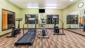 Un gimnasio con cintas de correr, elípticas y bicicletas estáticas.