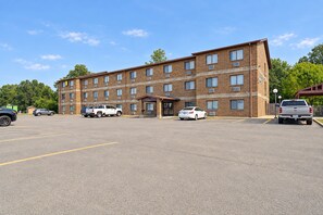 A multi-story brick building with a parking lot in front.