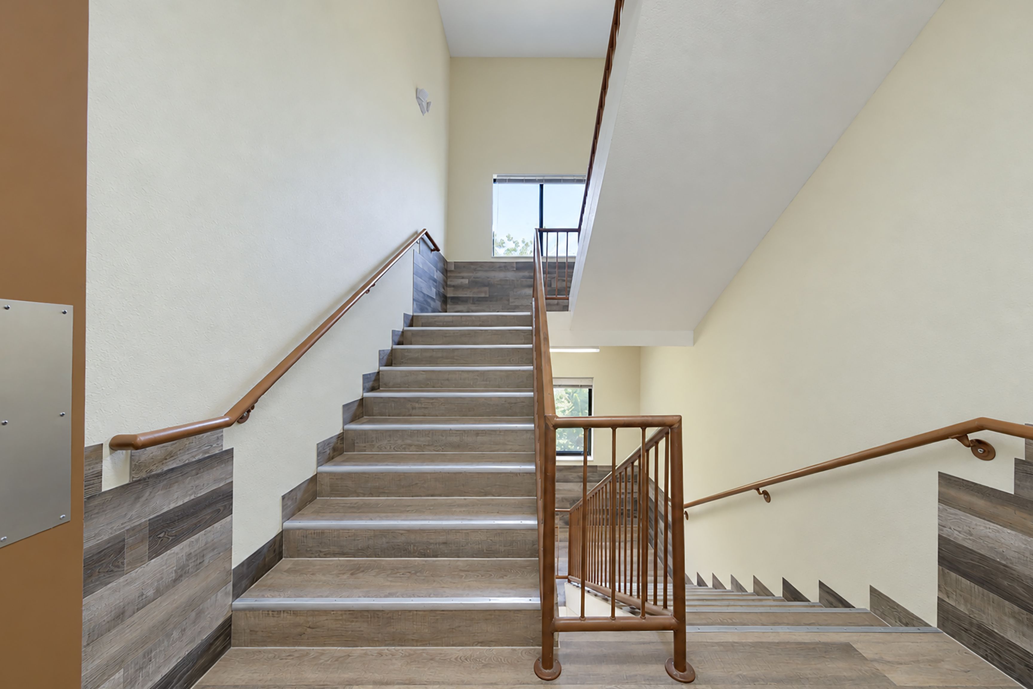 A staircase with wooden steps and metal handrails, leading to an upper floor.