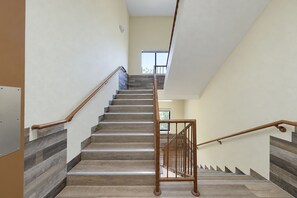 A staircase with wooden steps and metal handrails, leading to an upper floor. - Rockwood Inn Kennett I 55 Near Blytheville (Kennett)