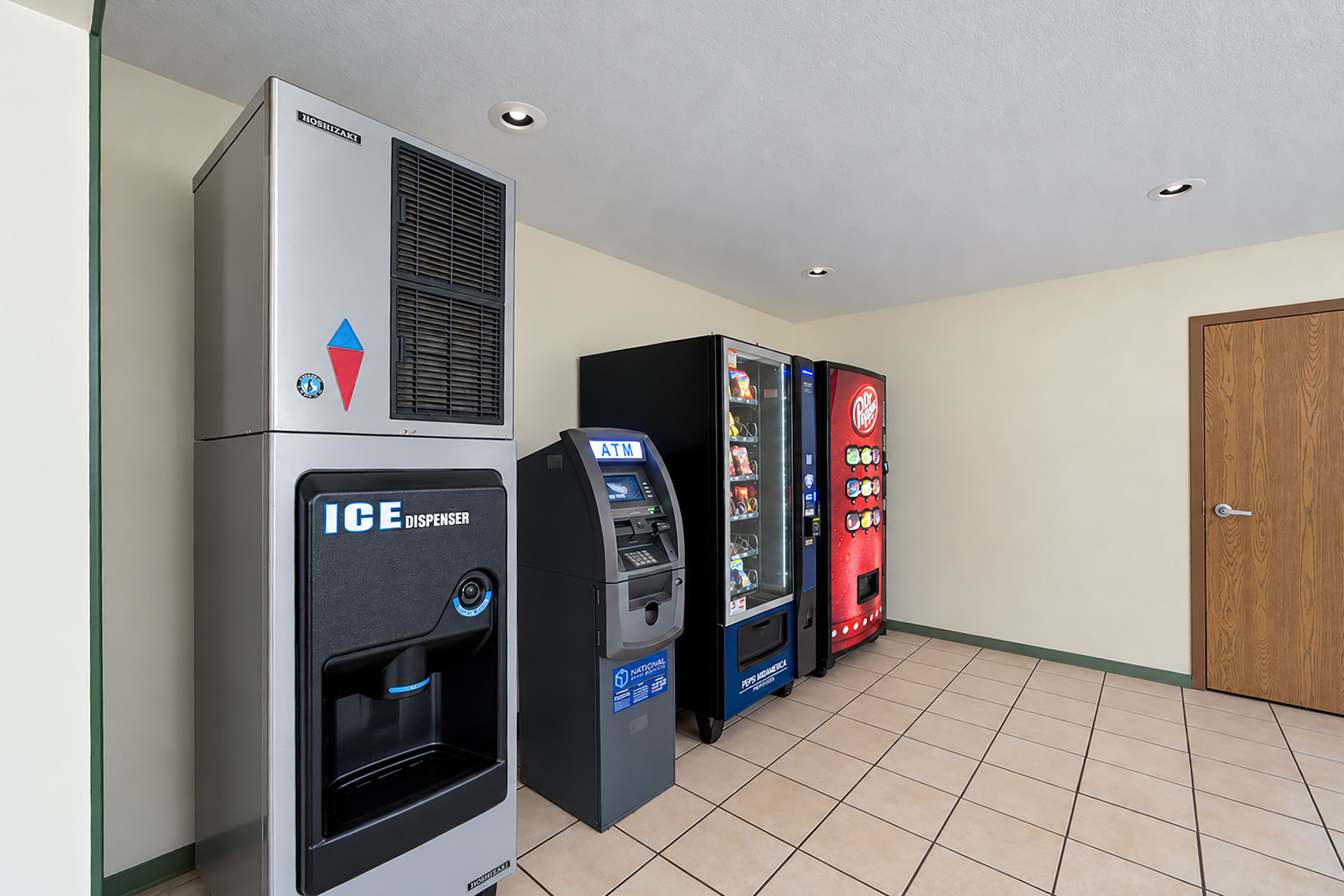 A hallway with vending machines, an ice dispenser, and a thermostat.