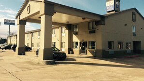 A hotel with a covered parking area, a sign indicating it is a Texas Inn & Suites, and a building number 2216. - Texas Inn & Suites (Lufkin)