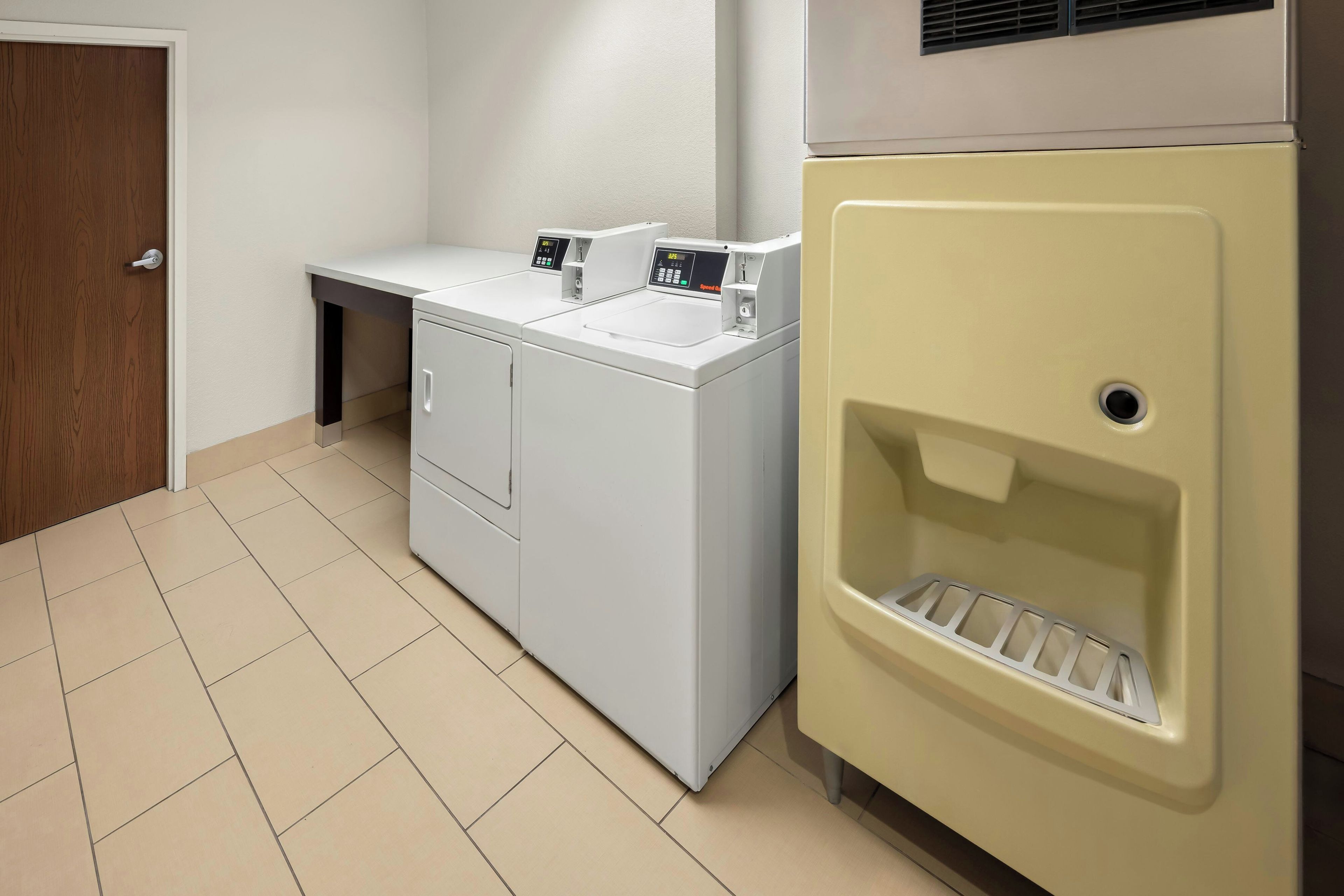 A laundry room with a washing machine, dryer, and a water dispenser.