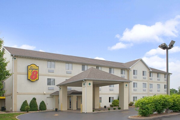 Un hotel Super 8 con entrada cubierta, varias ventanas y aparcamiento.