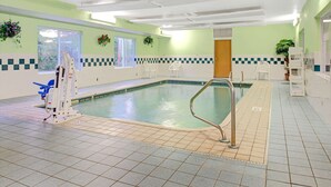 Une piscine intérieure équipée d’un poste de surveillance pour le sauveteur, d’un escalier d’accès et d’une rambarde de sécurité.