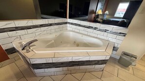 Une salle de bain dotée d’une grande baignoire, de murs carrelés et d’un design moderne.