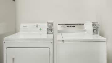 Dos lavadoras Whirlpool blancas de carga frontal una al lado de la otra en una habitación con paredes blancas.