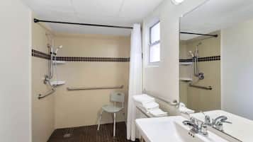 Une salle de bain équipée d’une douche, de toilettes, d’un lavabo et d’une chaise.