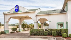 A hotel with a prominent 'Premier Inn' sign, a covered entrance, and a well-maintained garden area.