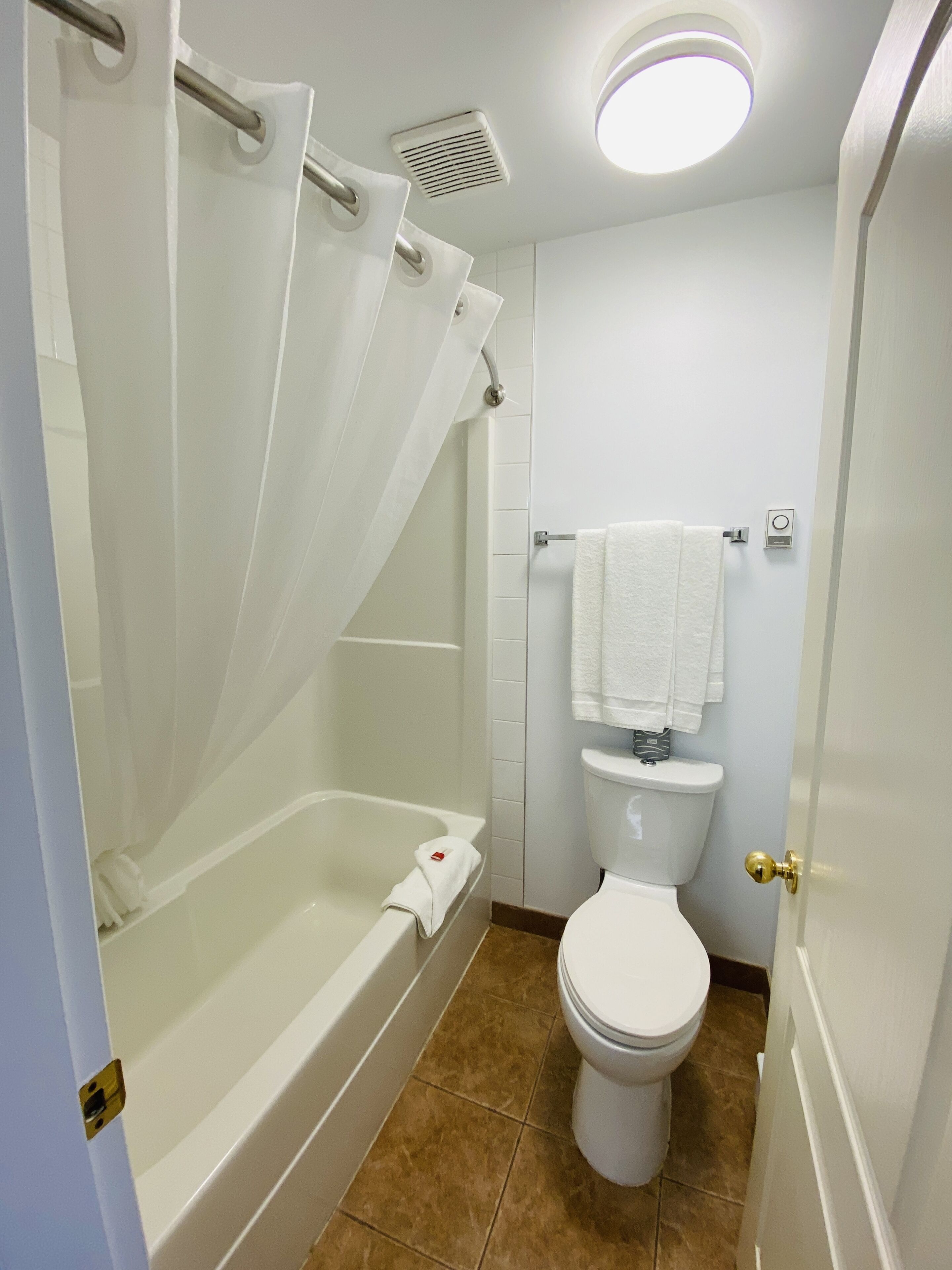 Une salle de bain avec une baignoire, des toilettes et un rideau de douche.