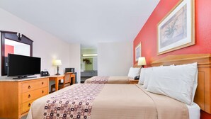 A hotel room with two beds, a desk, a television, and a painting on the wall. - Americas Best Value Inn Goodlettsville Nashville N (Goodlettsville)