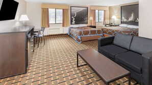 A hotel room with a bed, a sofa, a desk, and a TV.