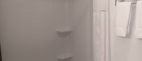 A bathroom with a bathtub, a toilet, and a shower curtain.