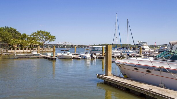 A marina with boats docked at wooden piers, calm water, and a clear sky. - Super 8 by Wyndham Port Royal/Beaufort (Port Royal)