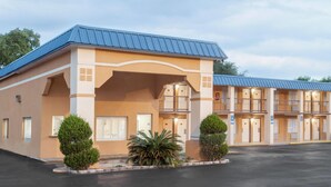 A motel with a blue roof, beige exterior, and multiple balconies. - Super 8 by Wyndham Port Royal/Beaufort (Port Royal)